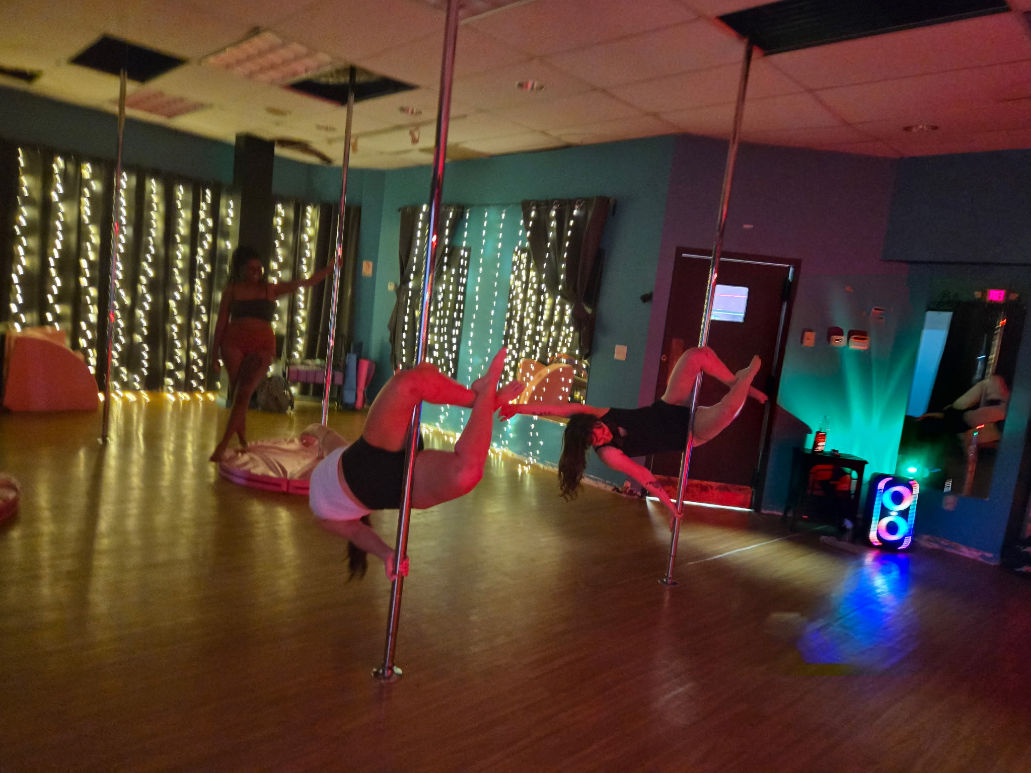 Two dancers on the pole at Free Flow Fitness